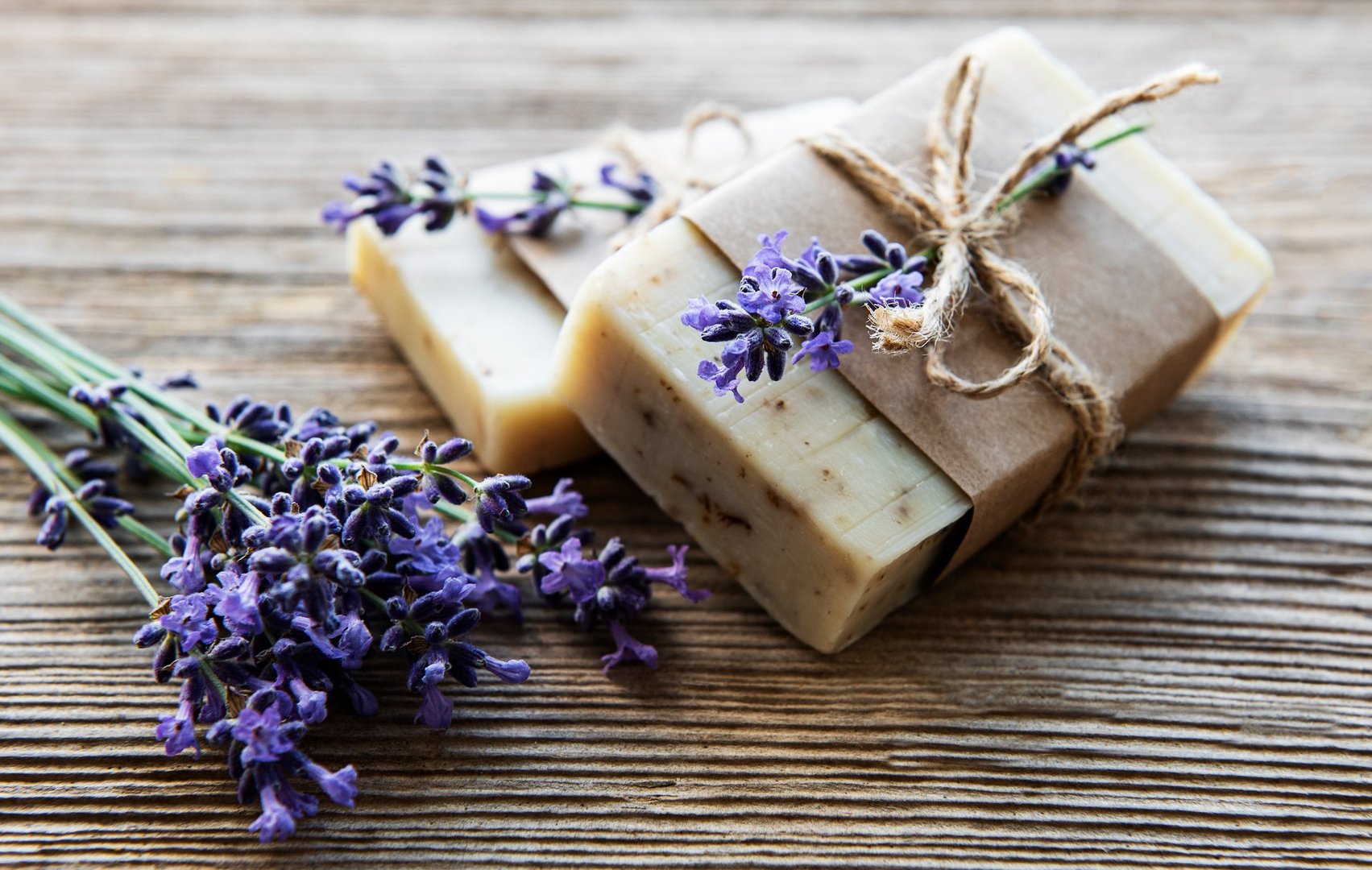 Bars of handmade soap with lavender flowers over  wood grunge background.