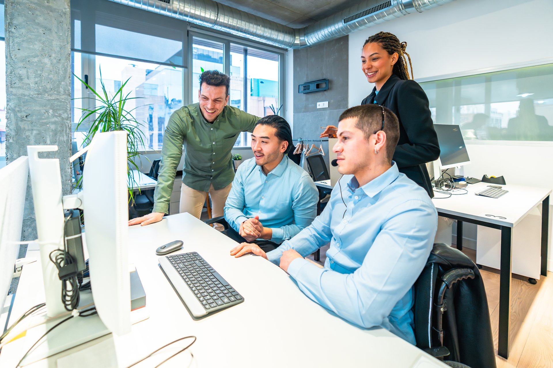 Diverse team of customer service representatives collaborates on a computer, providing efficient and friendly support