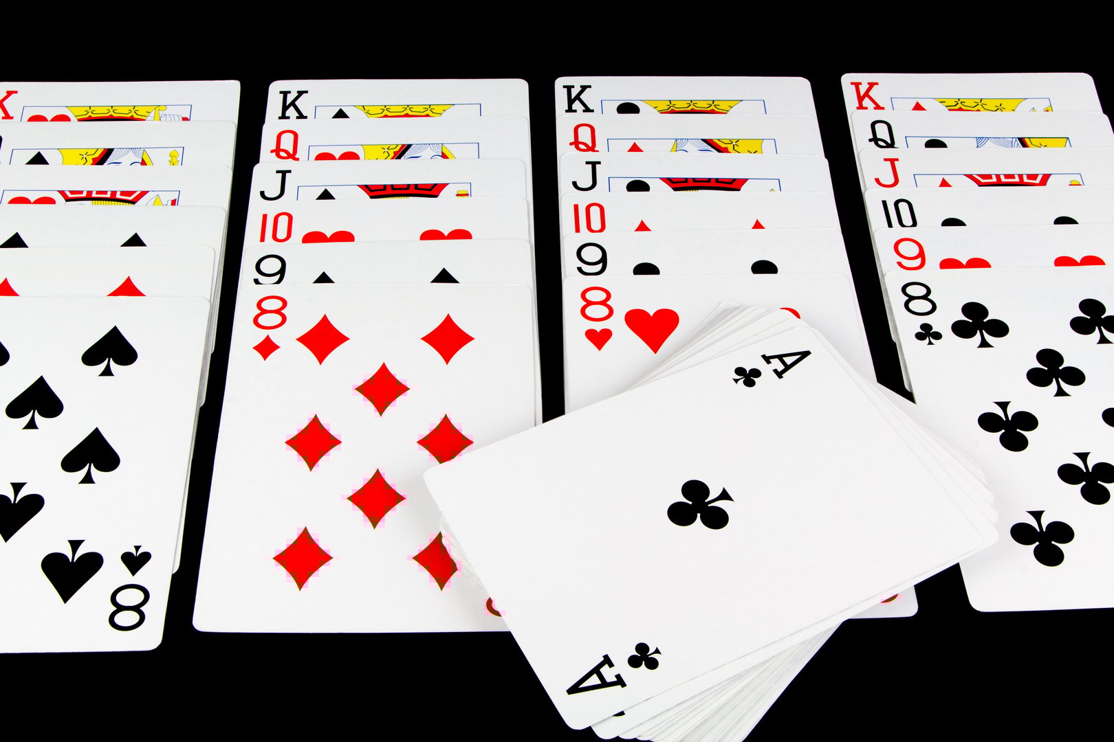 Playing cards being used for solitaire on black background