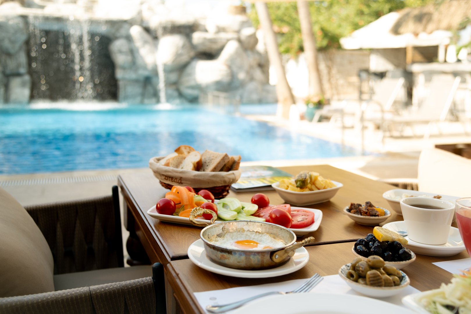 A delicious omelette with a side of fresh bread, perfectly set on a poolside breakfast table, ready to enjoy
