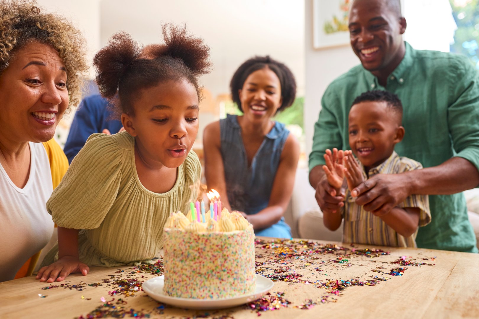 Multi-Generation Family Celebrating Granddaughter's Birthday At Home With Cake And Party