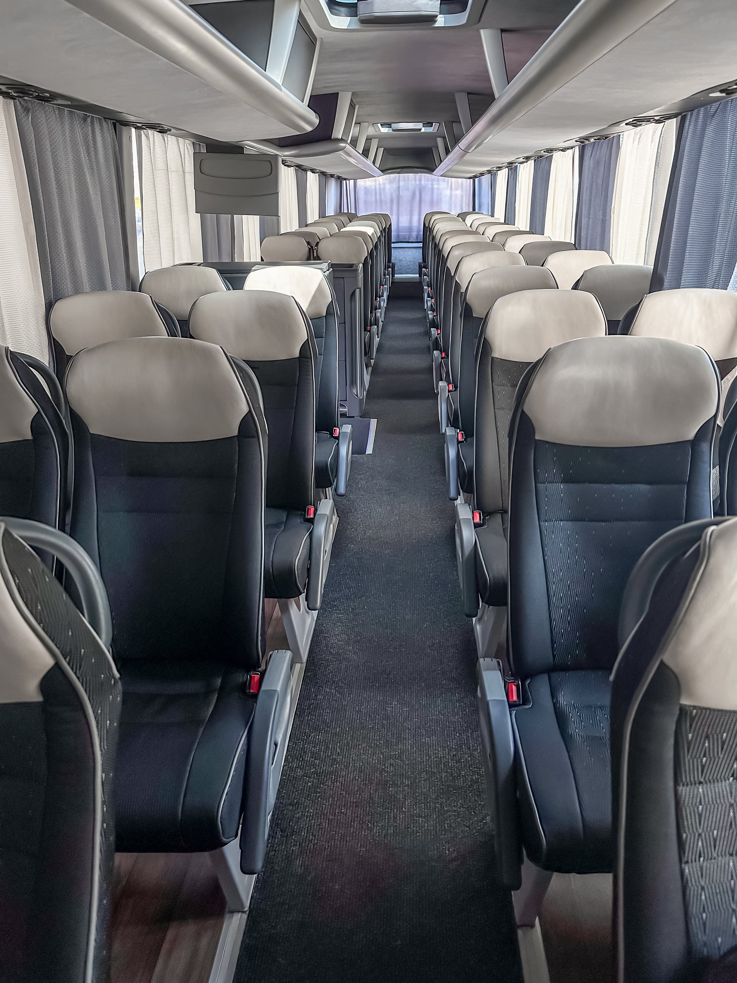 Interior of coach bus rows of seats with no people from aisle