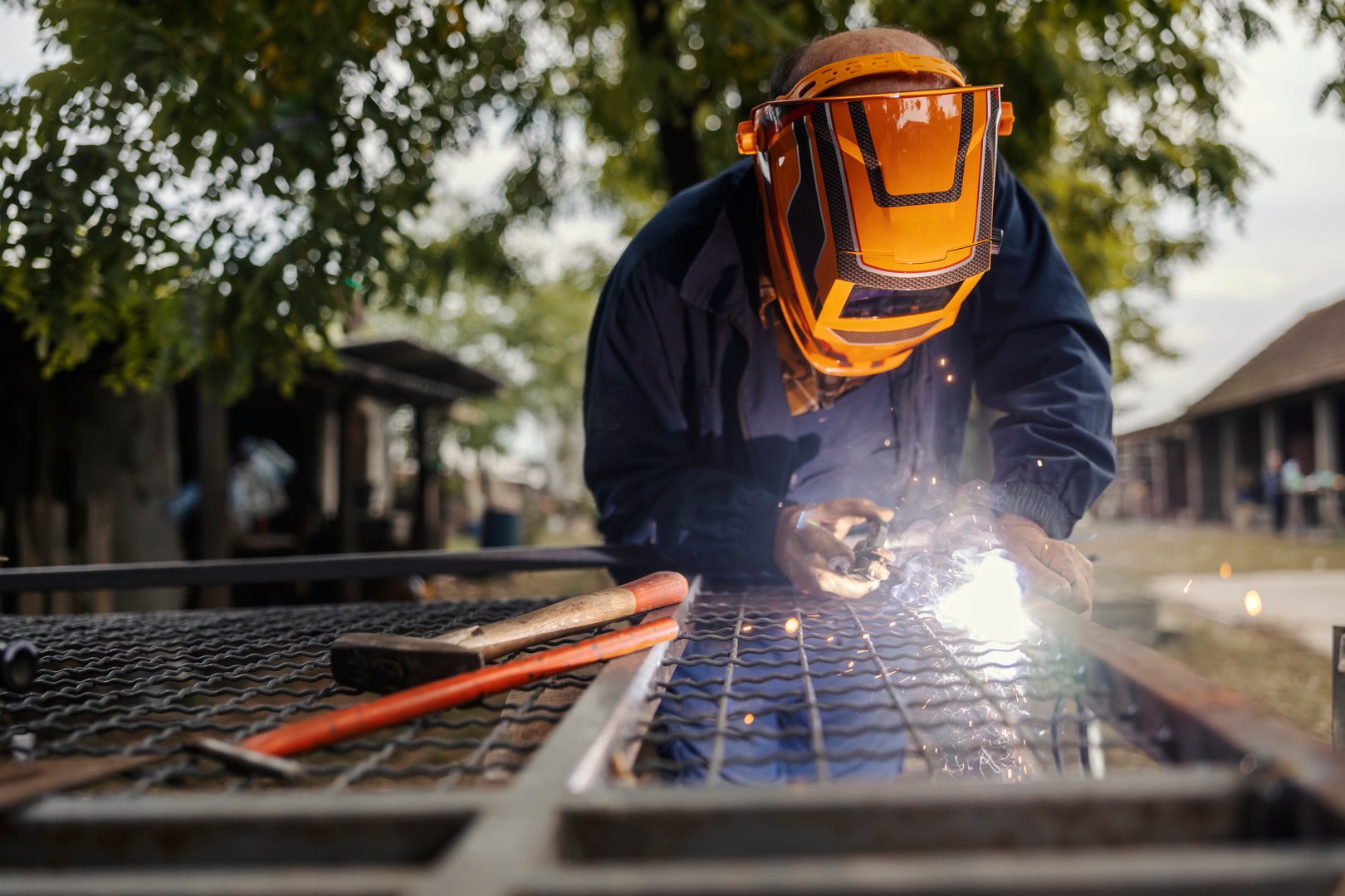 Worker welding with protective mask and sparks flying