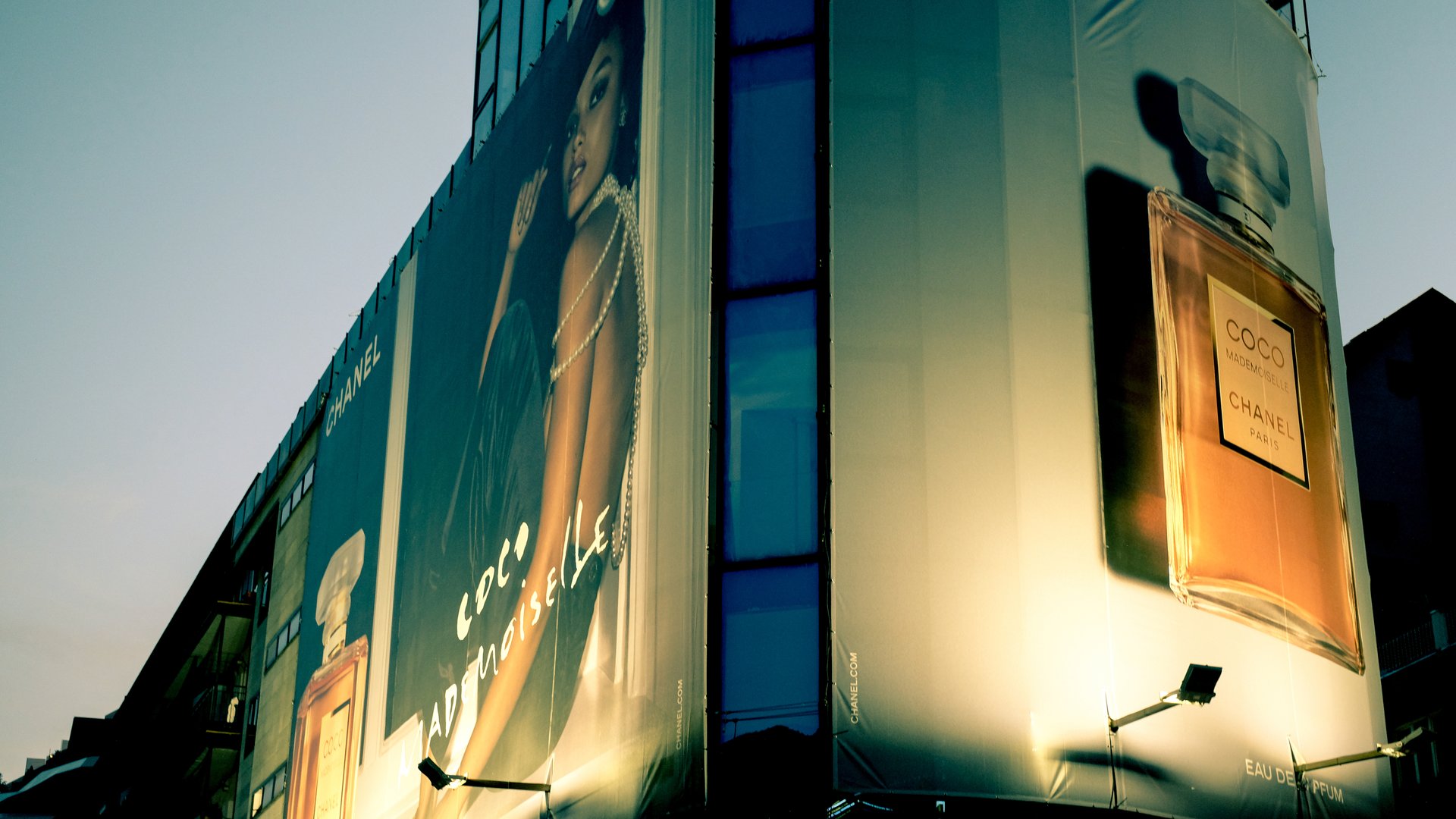 Andorra, Pyrenees , France - Aug 2025.  A Large Perfume Billboard Advert on a Building.  Evening Night Photo Atmospheric Mood Copy Space Idea Travel Shopping Destination