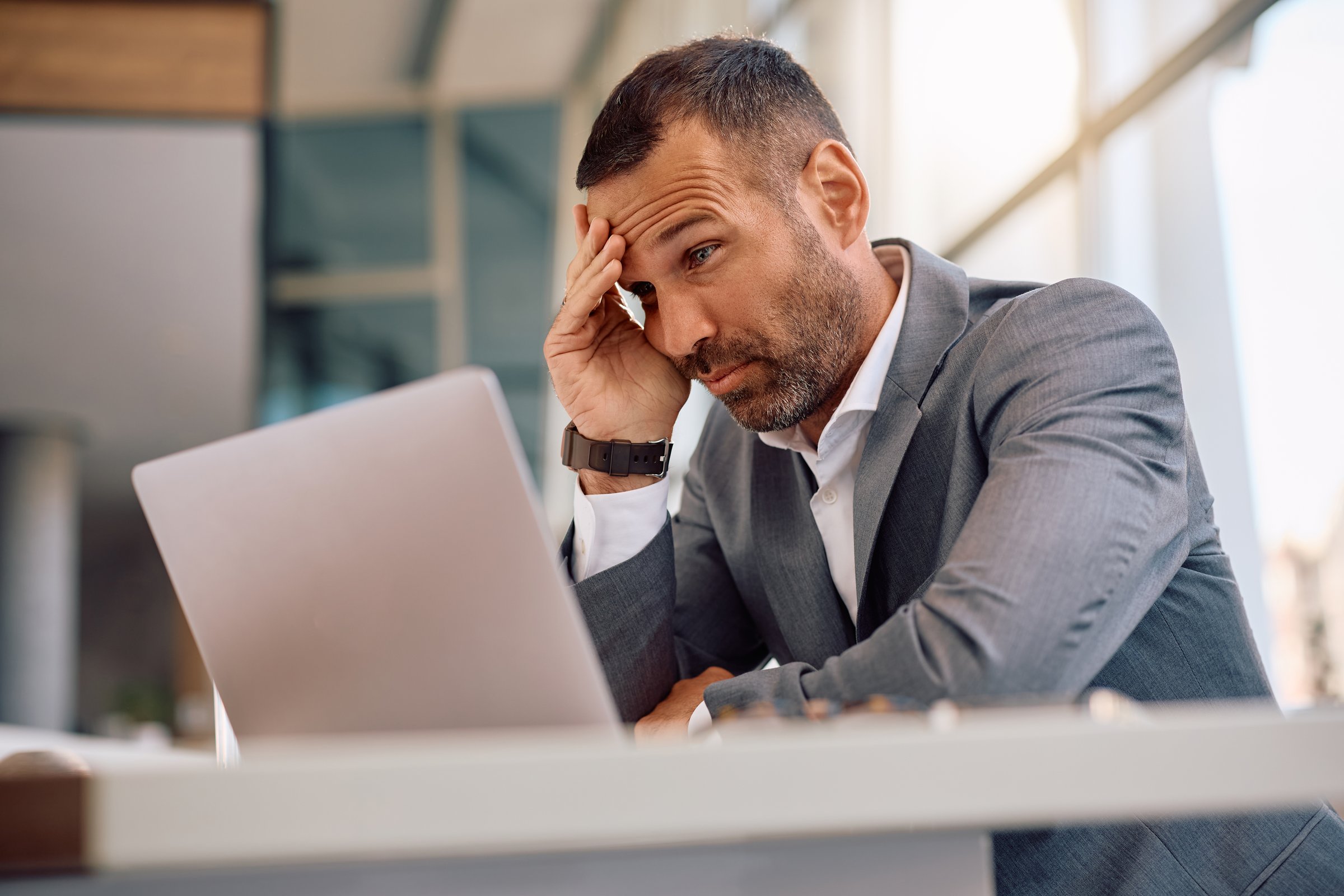 Stressed businessman working on laptop in the office.