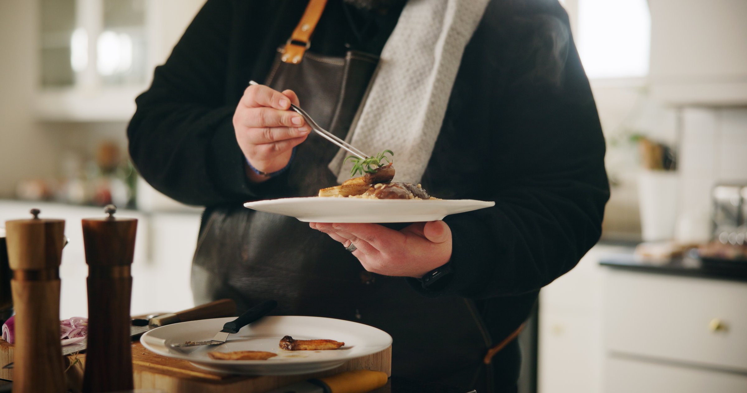 Chef, plate and hands of man with food in kitchen of home for diet, private service or nutrition. Ingredients, recipe and preparation with dish in house for gourmet cuisine, hospitality and lunch