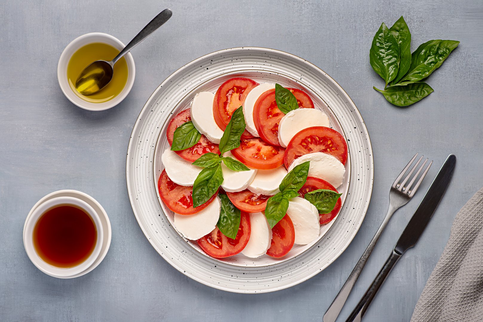 Food photography of salad caprese with mozzarella cheese, tomatoes, basil, olive oil, italian cuisine, healthy natural dish