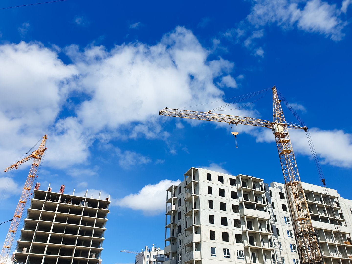 Construction of apartment building from concrete, monolithic slabs. Industrial construction of houses,developer company,construction crane.