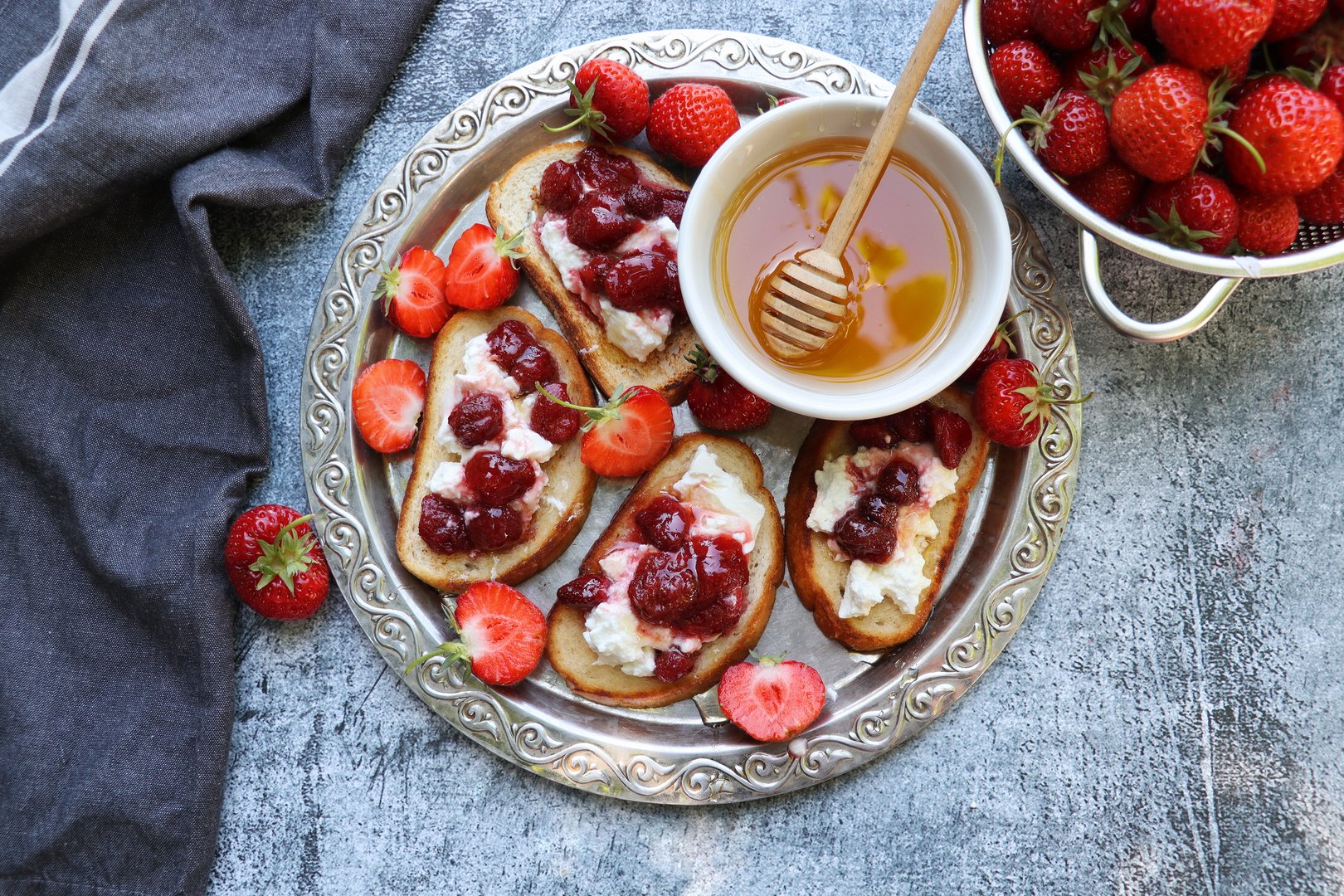 Sandwich with strawberries, soft cheese and honey on wooden board