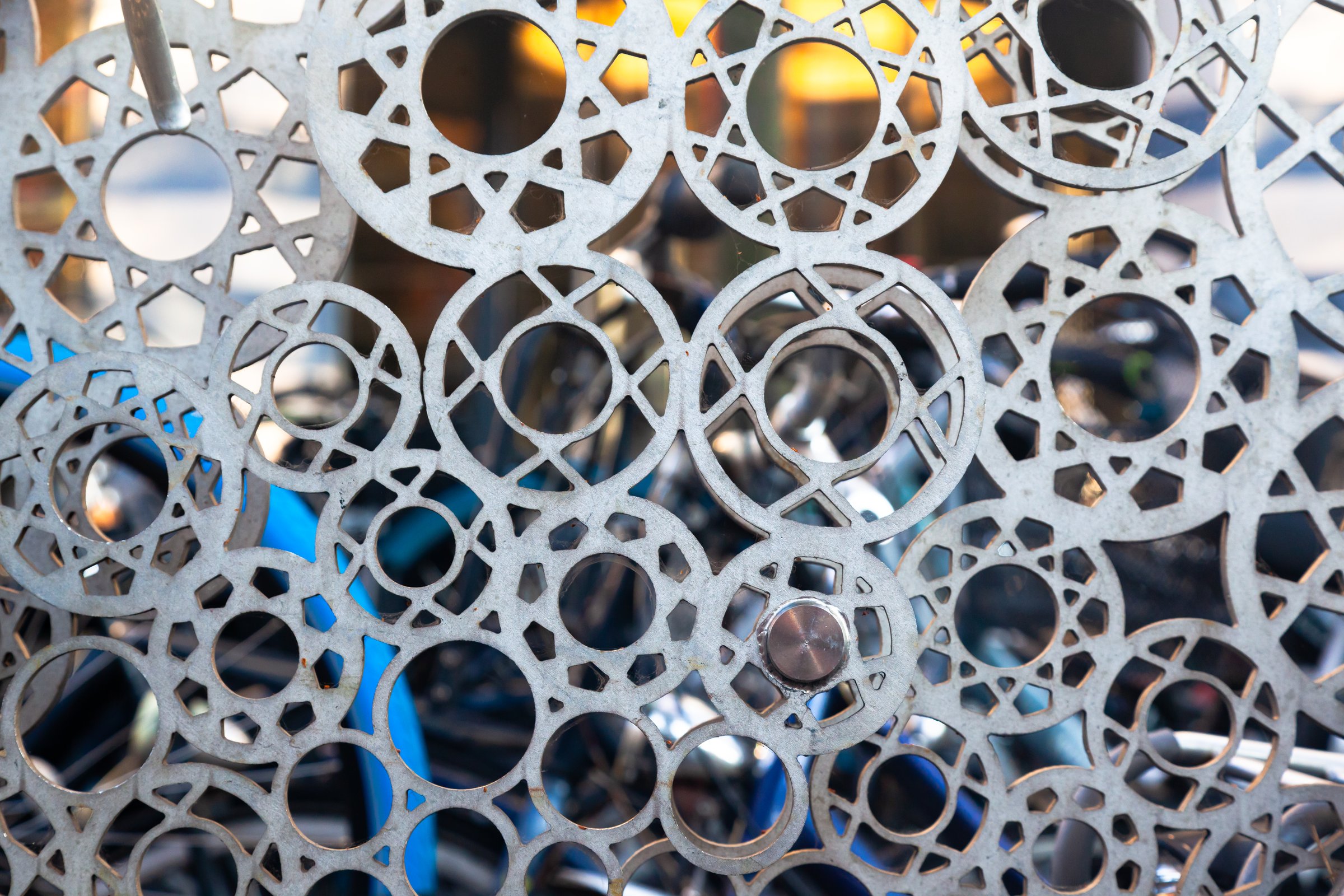 Decorative steel fencing in the form of round shapes with various geometric cutouts.