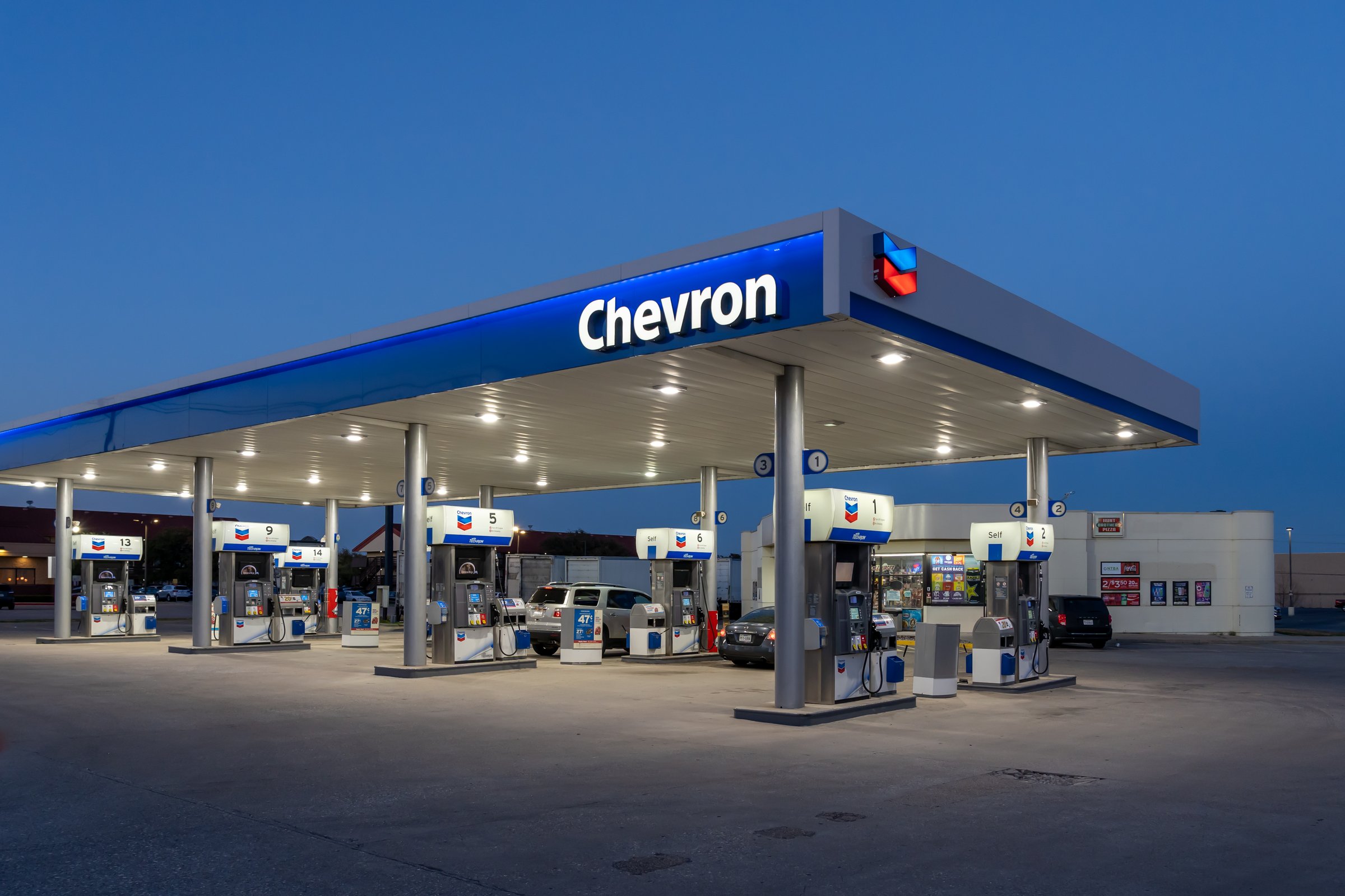 Dallas, Texas, USA - March 19, 2022: A Chevron gas station at night is shown in Dallas, Texas, USA. Chevron Corporation is an American multinational energy corporation.