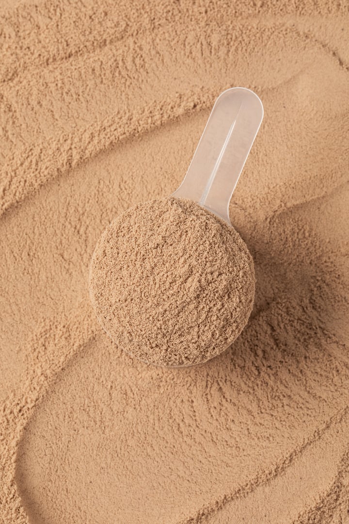 Chocolate protein powder in a skimp on the background of protein powder for health and fitness. The concept of sports nutrition.