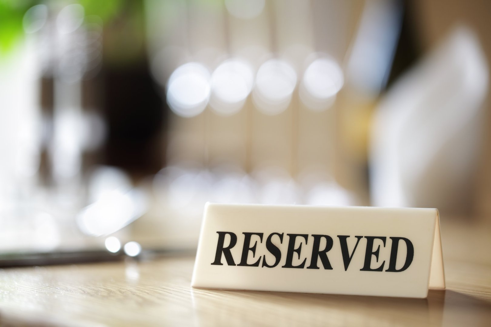 Restaurant reserved table sign with places setting and wine glasses