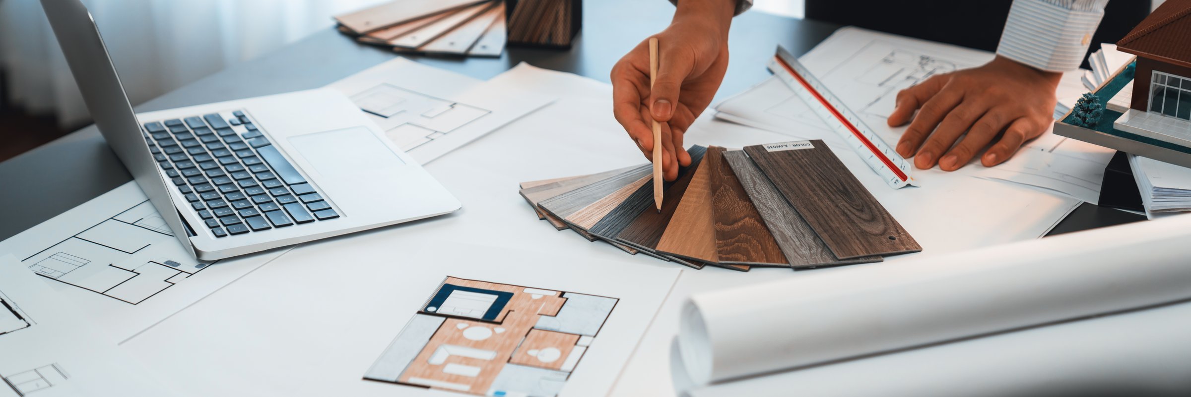 Interior architect designer at workstation table designing house interior blueprint and choosing mood board samples. Creative hand drawing sketch plan for house renovation or design concept. Insight