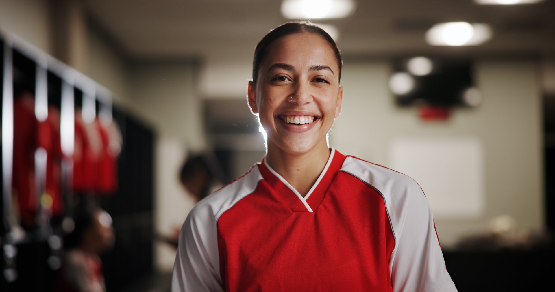 Happy girl, portrait and soccer player in locker room for professional sport, game or match preparation. Face, female person or athlete with smile for football tournament, competition or challenge