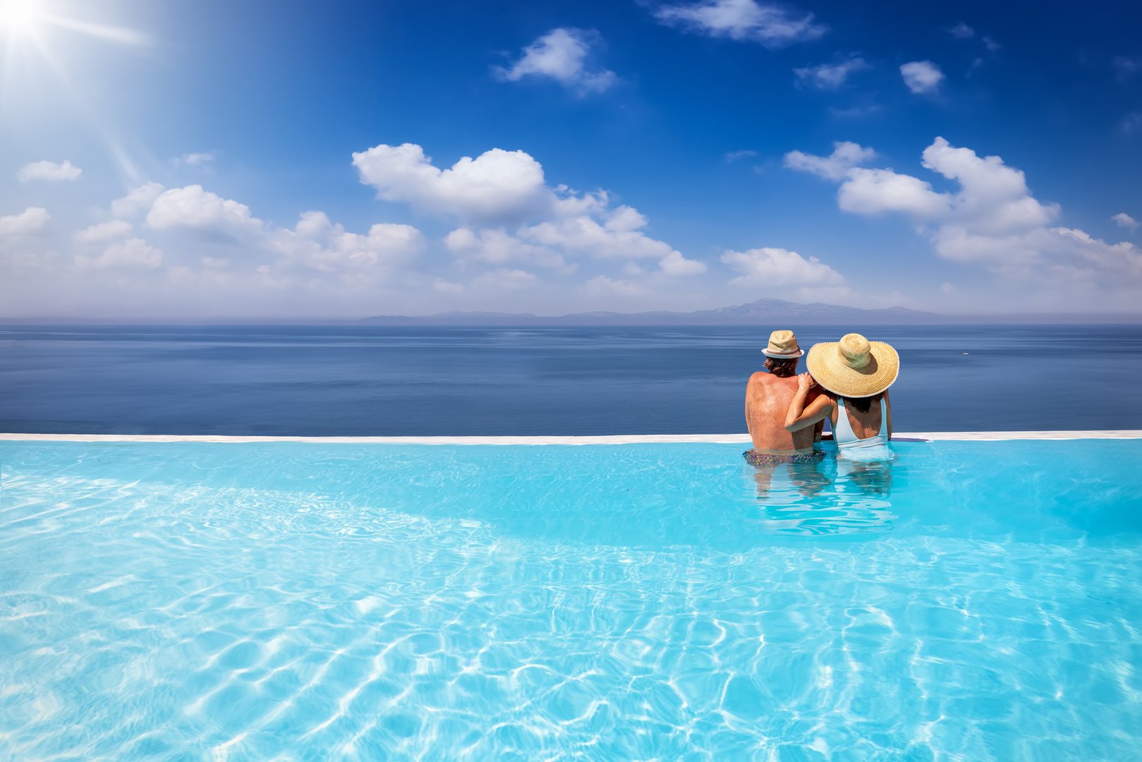 Couple enjoying infinity pool ocean view