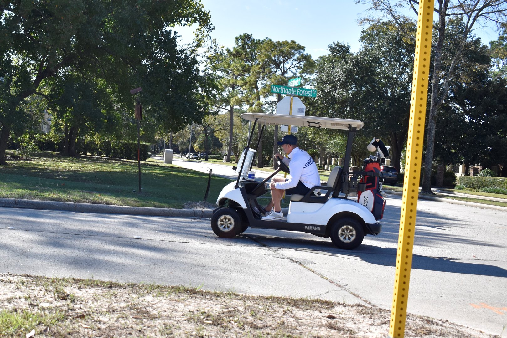 Houston, TX USA November 28, 2025 - A dynamic portrait of a golfer pulling away in a sleek Yamaha electric golf cart, captured on the scenic fairways near Cedarwoods Place and Northgate Forest Drive