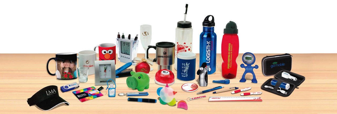 Assorted promotional items on a wooden surface, including mugs, pens, water bottles, and branded merchandise.