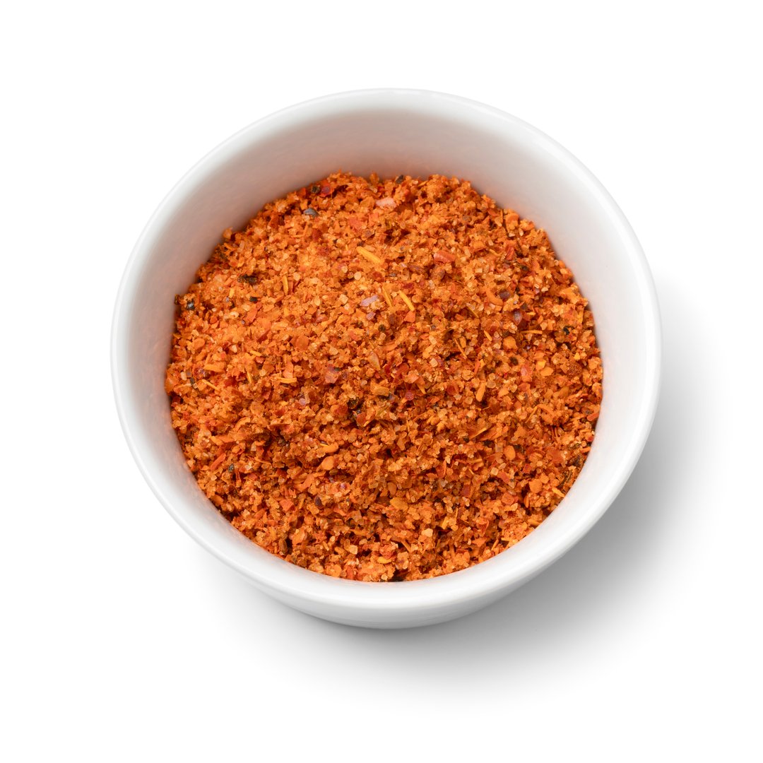 Single bowl with a mixture from Mexican seasoning made from chili, lime and sea salt isolated on white background close up