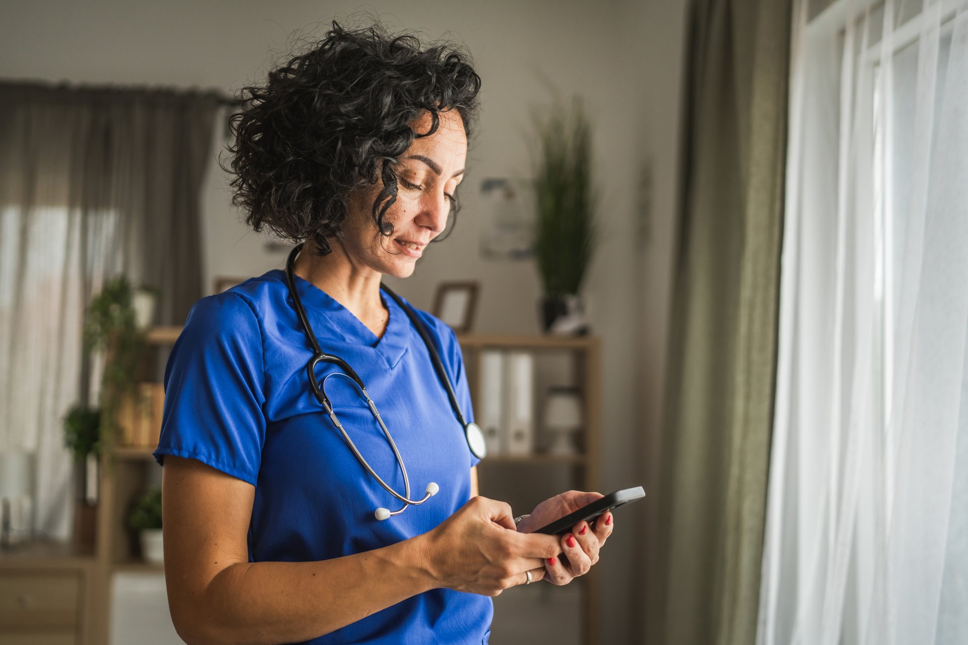 mature woman doctor stand and use mobile phone at home
