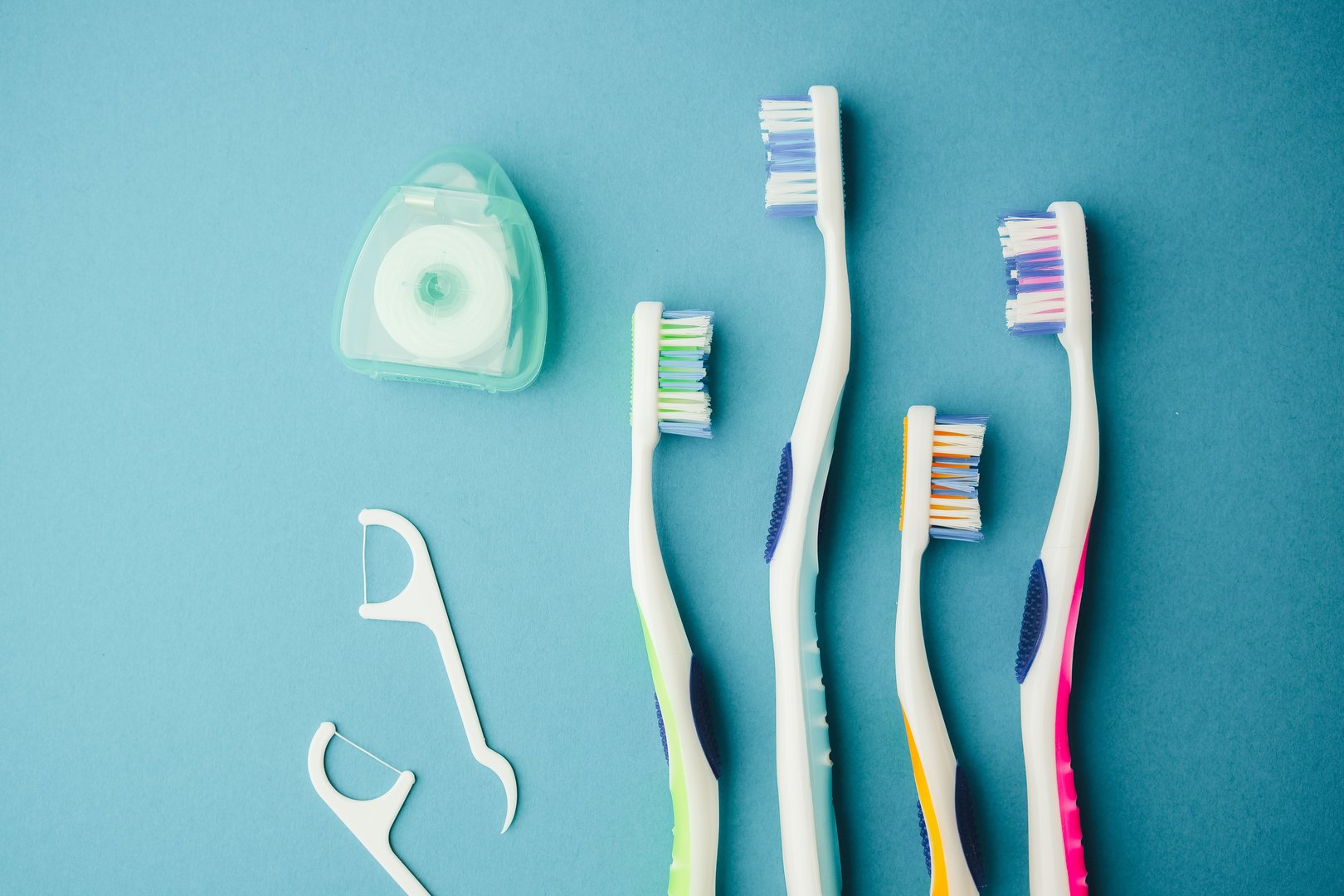 Set of toothbrushes and dental floss on a blue background for oral hygiene and care