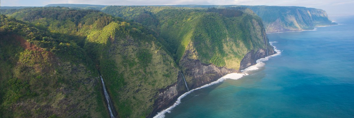 Waterfall flowing into ocean - aerial view of Big Island