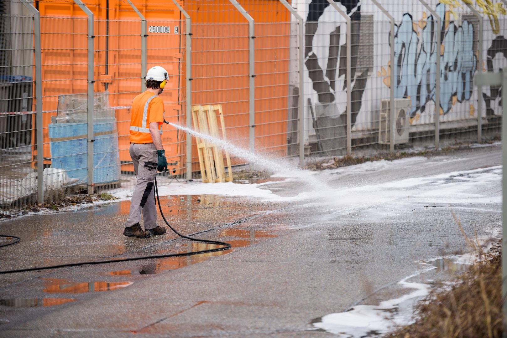 Strasbourg, France - Mar 10, 2021: Man cleans street after burnt remains of the large data center - Millions of websites offline after fire at French cloud services firm OVH Cloud in Strasbourg France