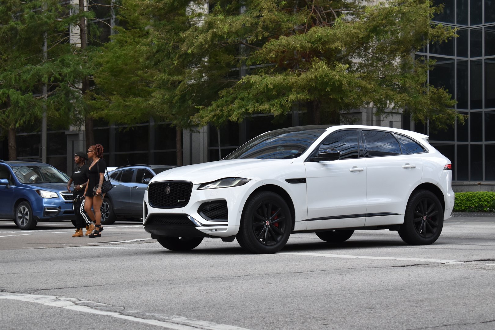 Houston, TX USA 10-4-2024 - A white and black Jaguar E-Pace EV SUV, cruising in the downtown financial district of the city.
