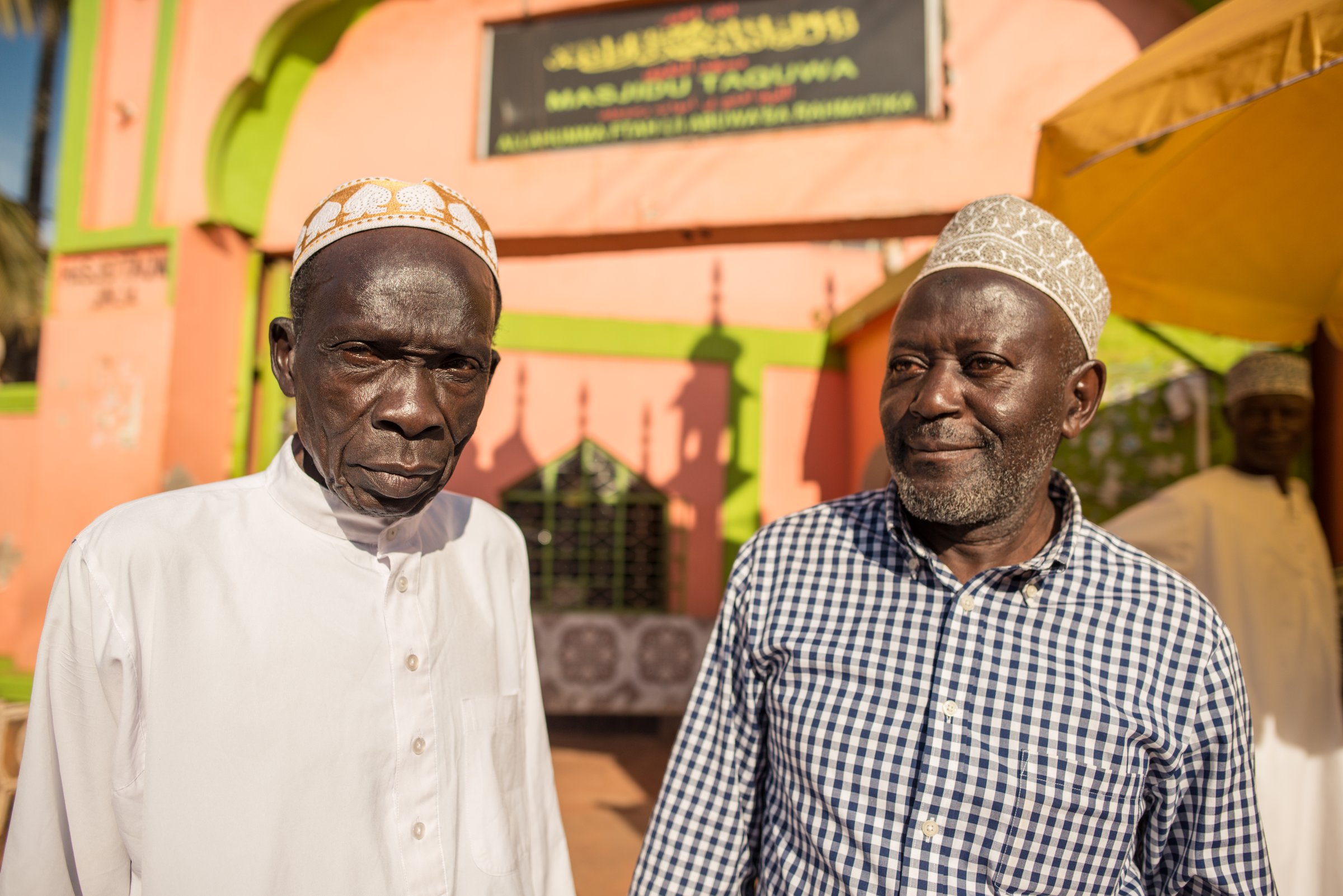 Jinja / Uganda - September 30, 2016: African Muslim man in front of mosque gate in Uganda with traditional clothes