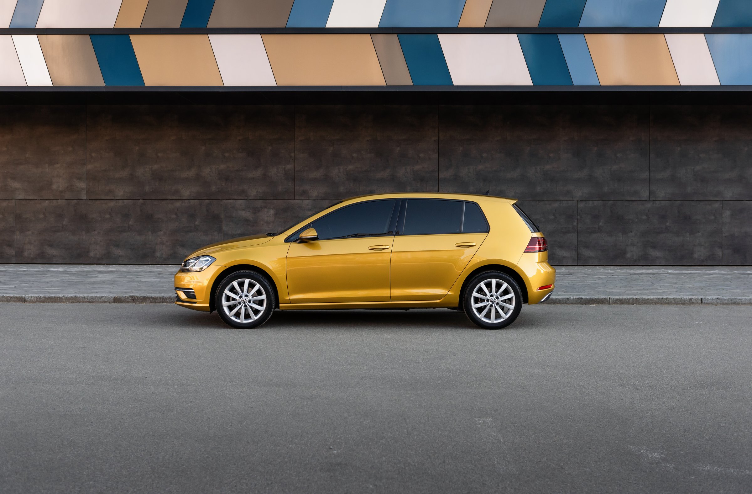 Side profile view of german hatchback parked in a city near modern building. Kyiv, Ukraine - April 28 2024