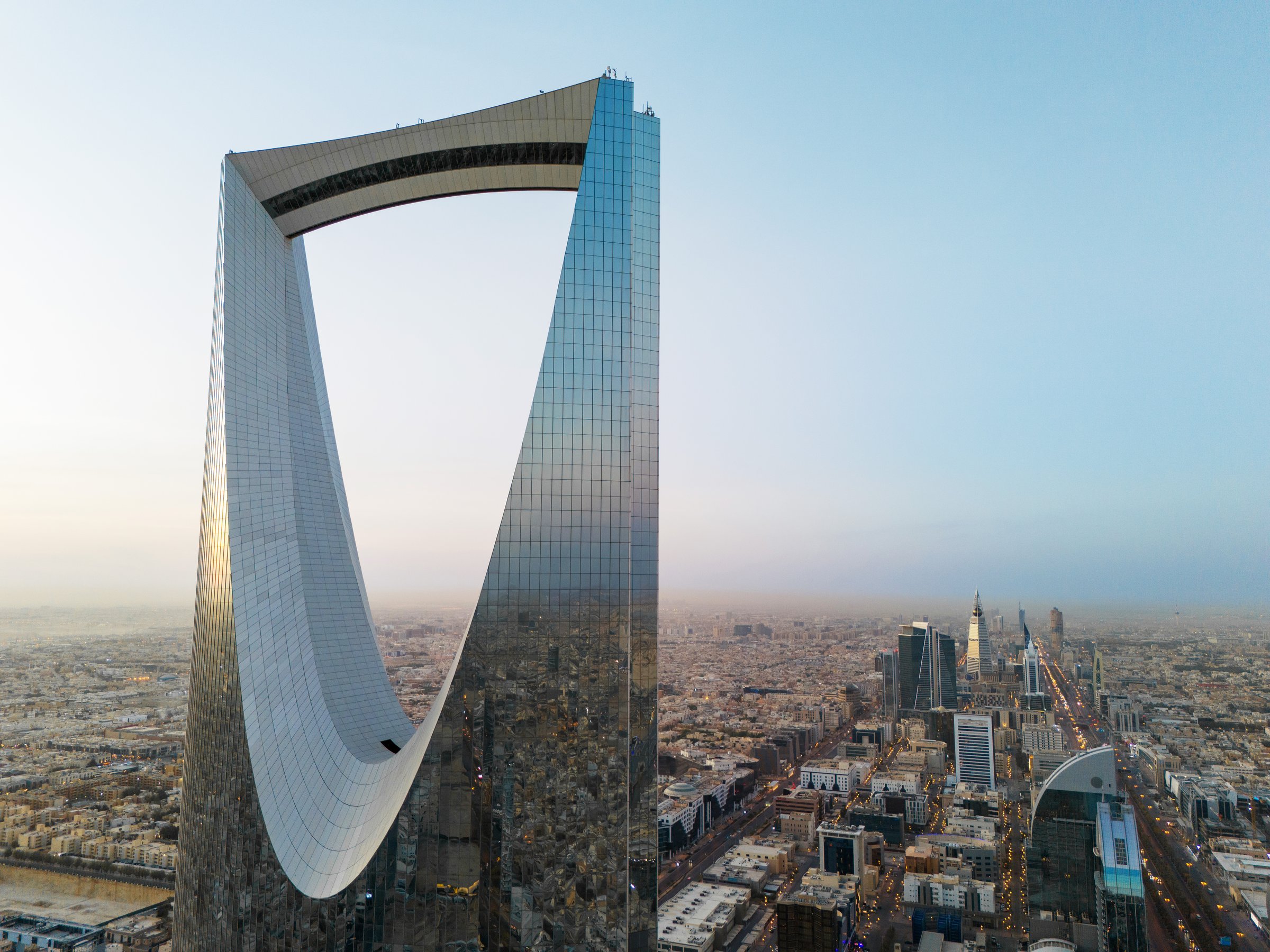 This drone shot unveils Riyadh, Saudi Arabia, in the vibrant light of day. Sunrise. Kingdom Tower The intricate crossroads of roads weave through the city, a testament to urban planning. The landscape below is a bustling network, symbolizing Riyadh&#039;s dynamic life and forward momentum during daylight hours. High-quality photo. Still image.
