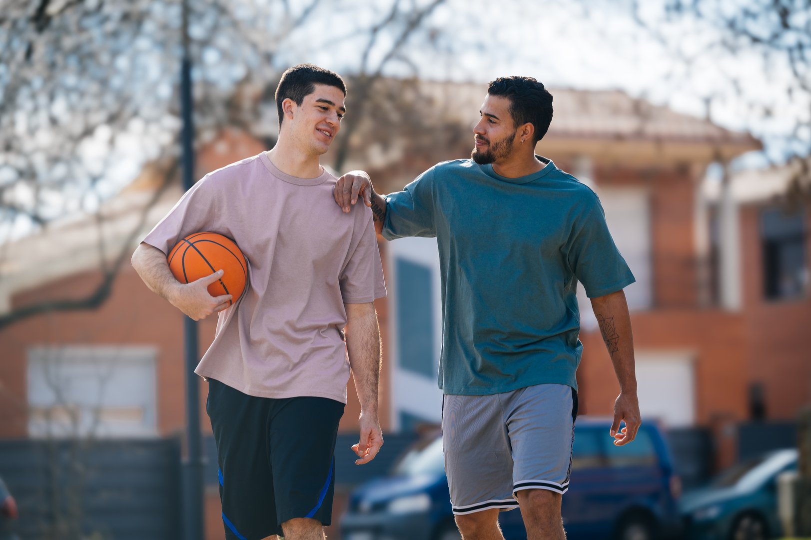 Two friends are walking and chatting after a basketball game in the city