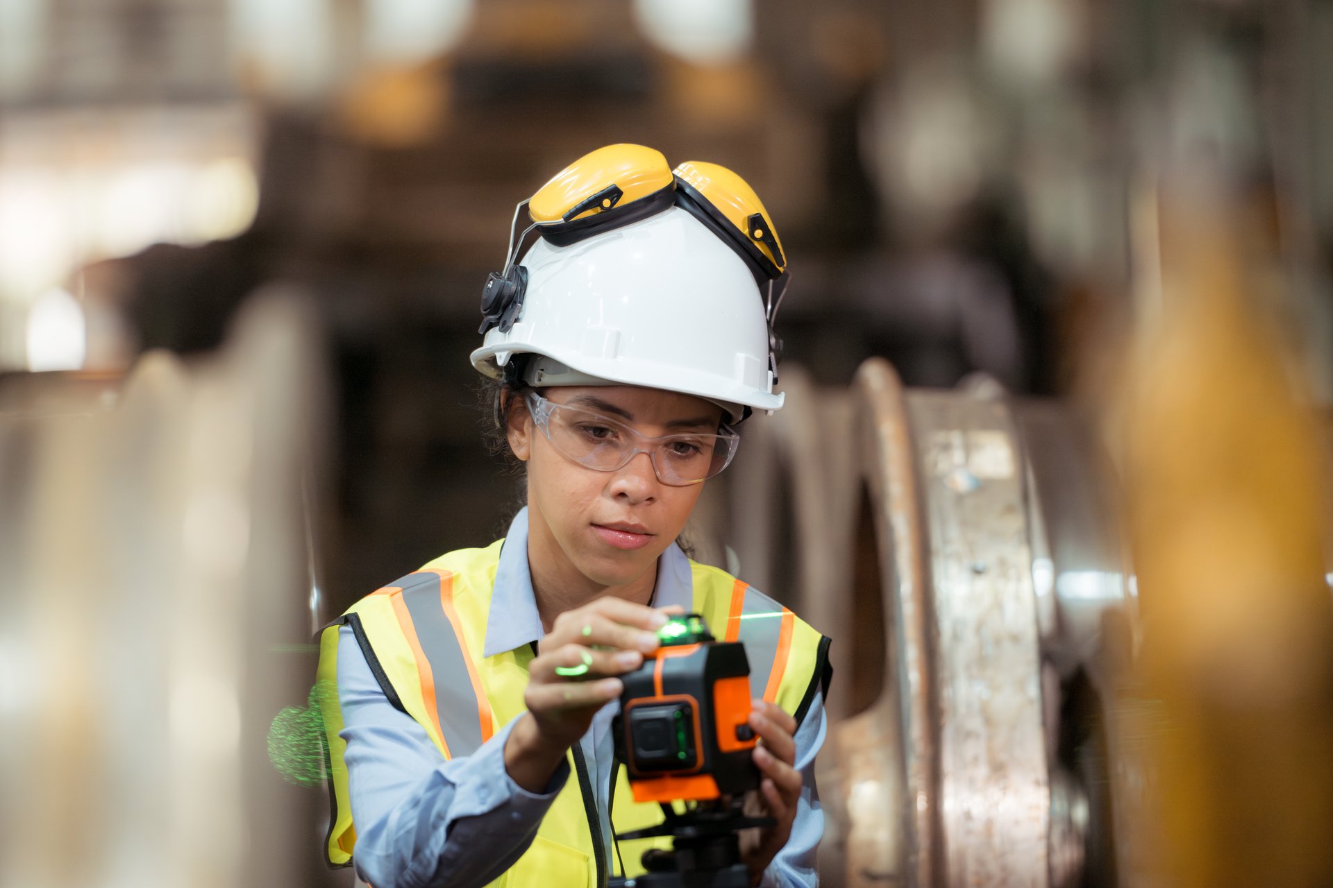 Railway technician in uniform and helmet inspect the train wheels removed from the locomotives in the train workshop.