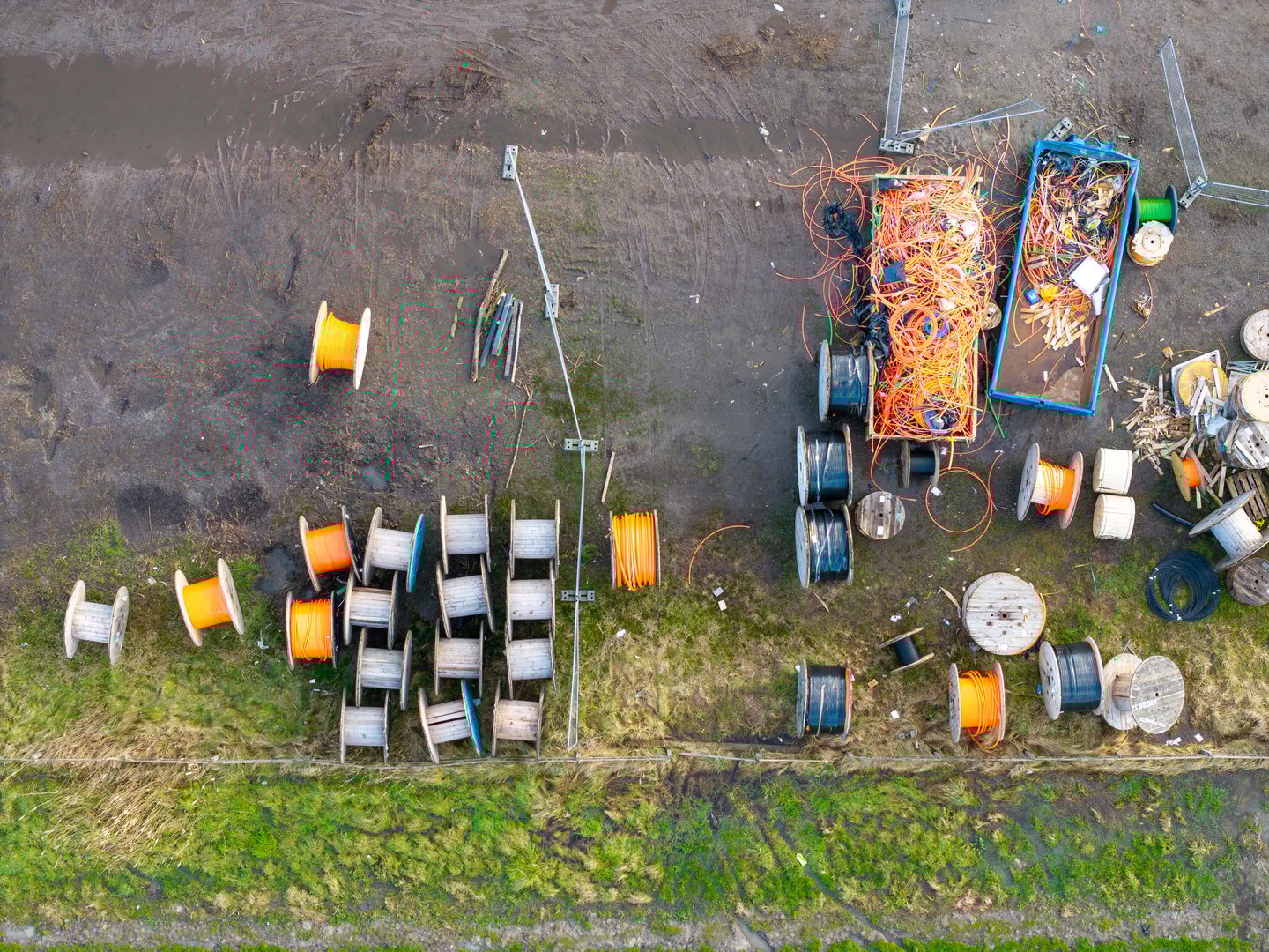 Top down aerial of rolls of fiber optic internet cable and conduit pipe for construction