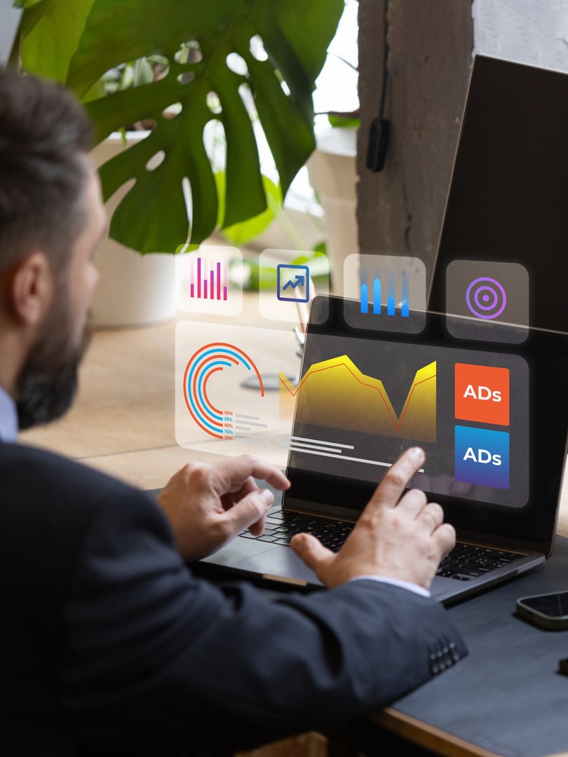 Businessman in suit analyzes marketing data, graphs, and ad performance on modern holographic screen. Concept of advanced digital tools in advertising workflows, digital campaign management