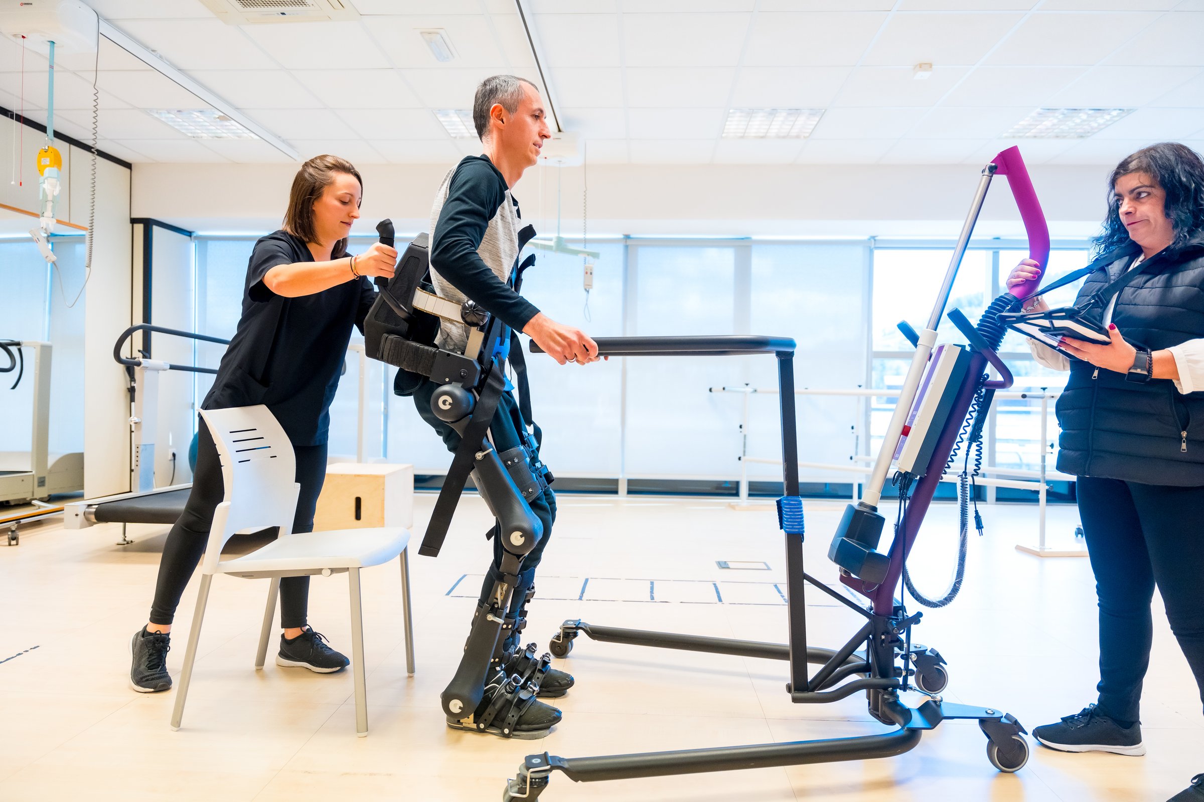 Mechanical exoskeleton. Physiotherapy medical assistant lifting disabled person with robotic skeleton to get up. Futuristic rehabilitation, Physiotherapy in a modern hospital
