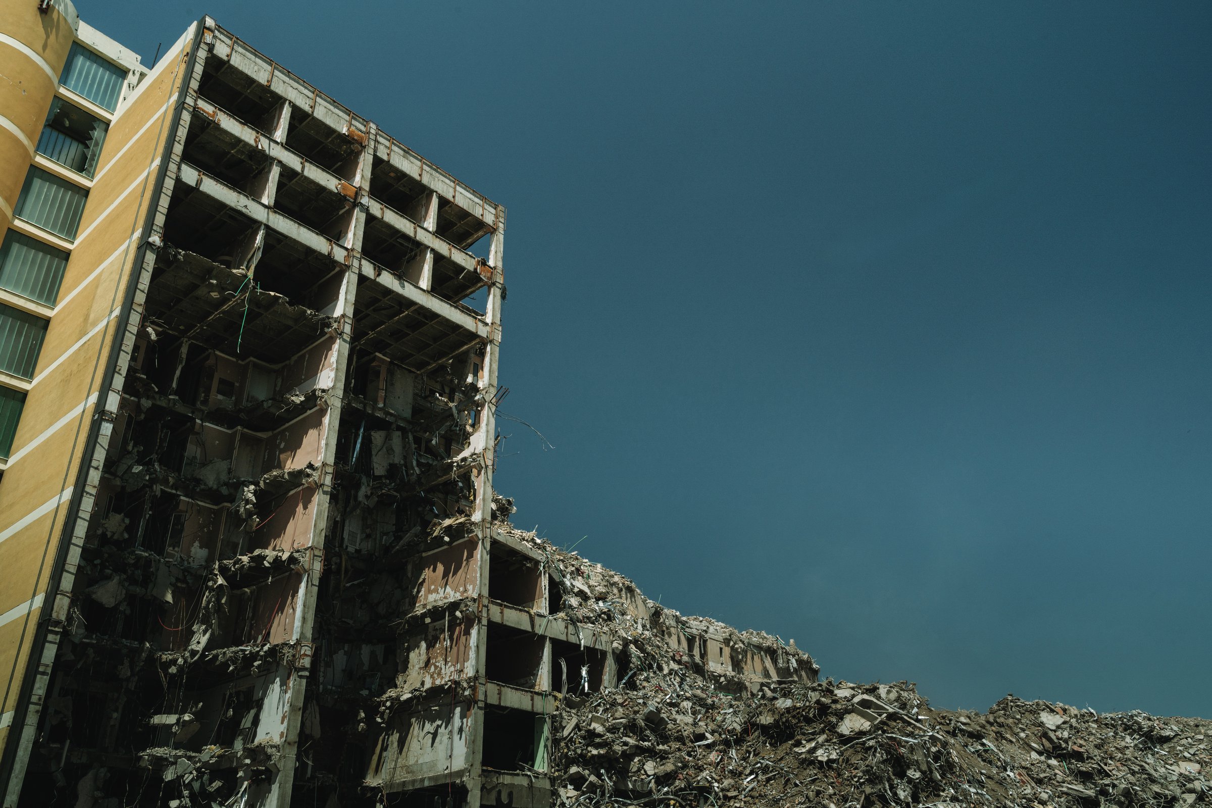 Collapsed multi-story building amid debris and dust