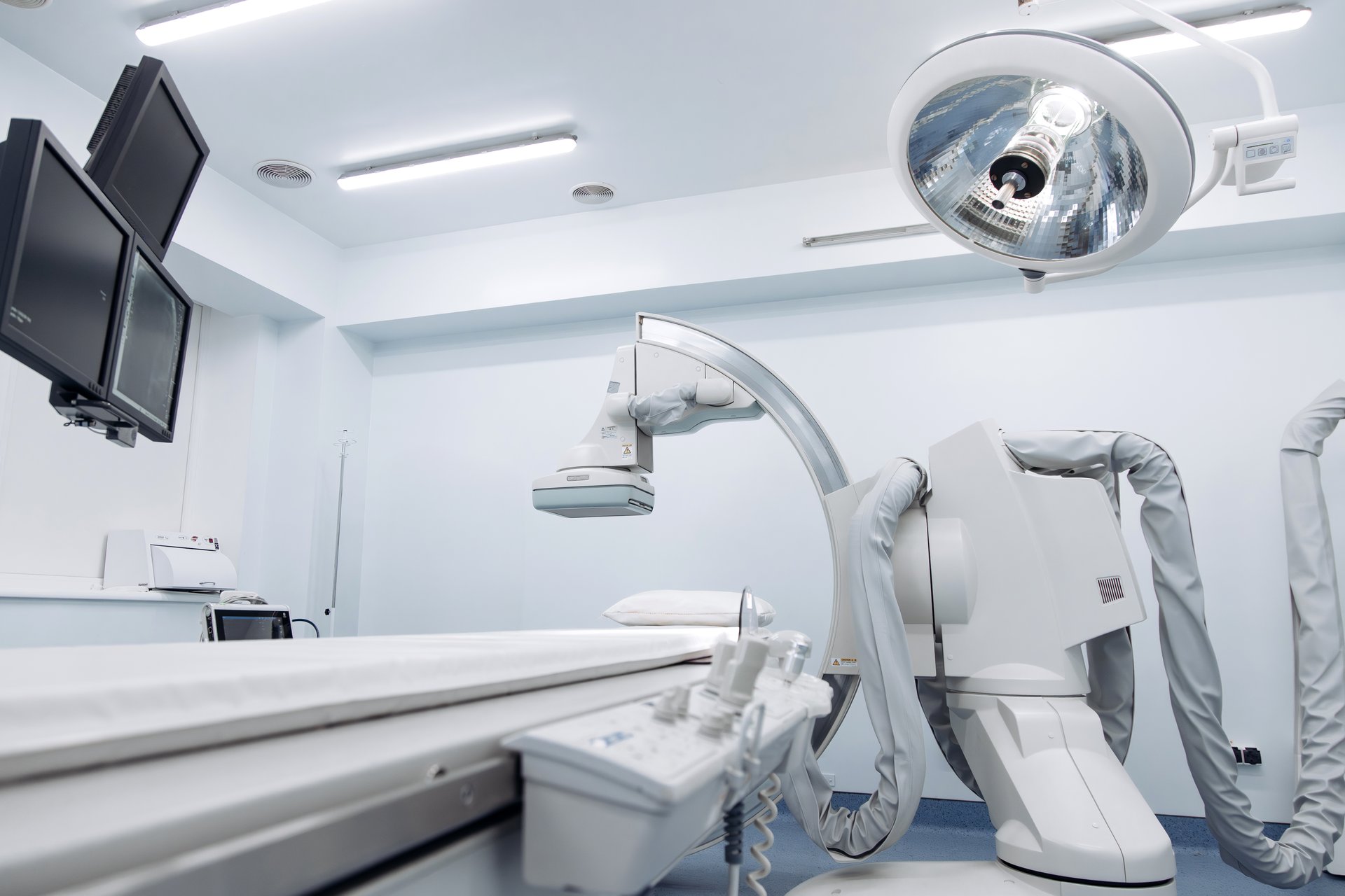 Angiograph machine in a modern medical facility, featuring advanced imaging technology, illuminated by bright overhead lights, showcasing a sterile environment for diagnostic procedures