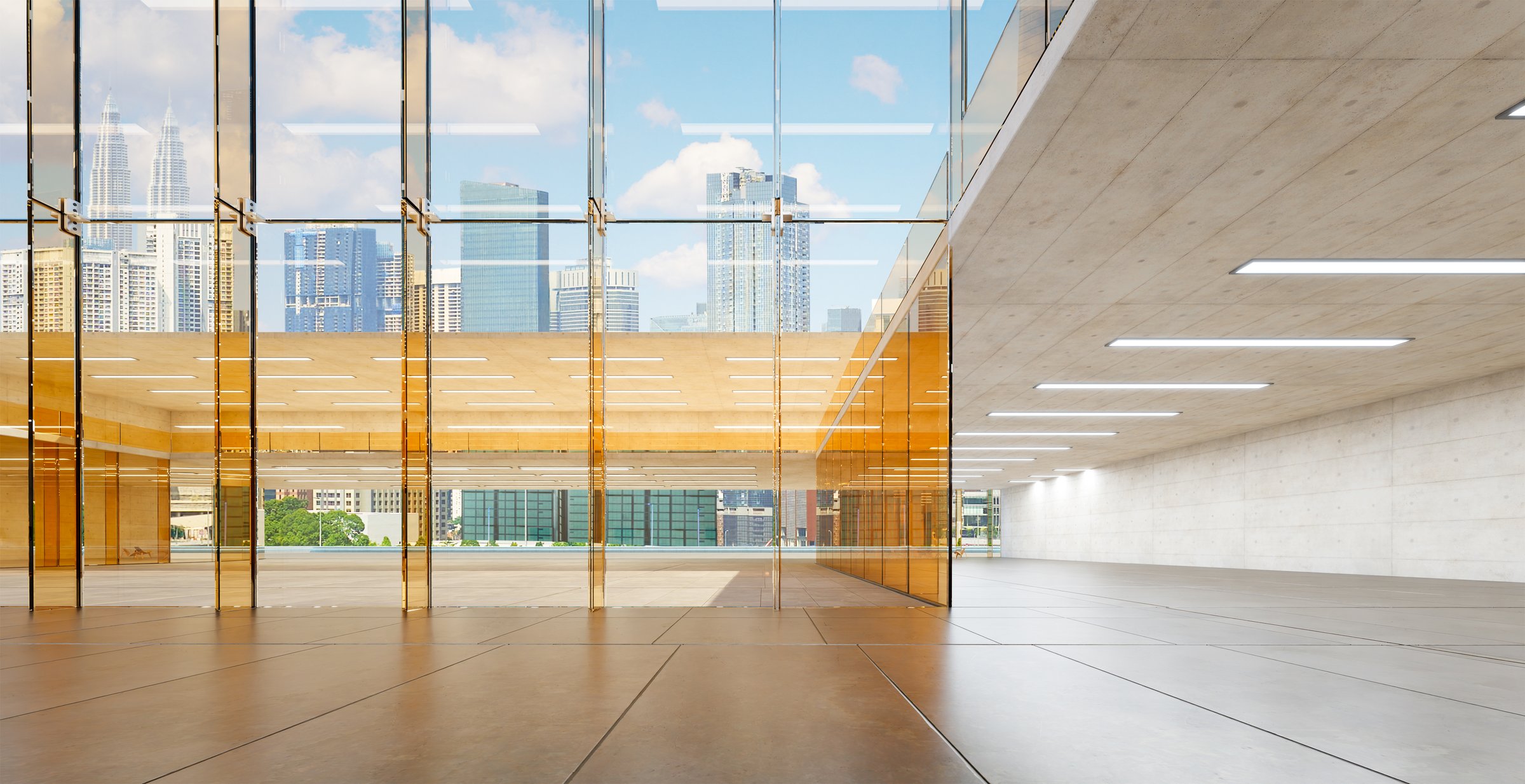 Bright and spacious contemporary interior featuring a concrete structure and large glass partitions offering a clear view of the urban cityscape and skyscrapers