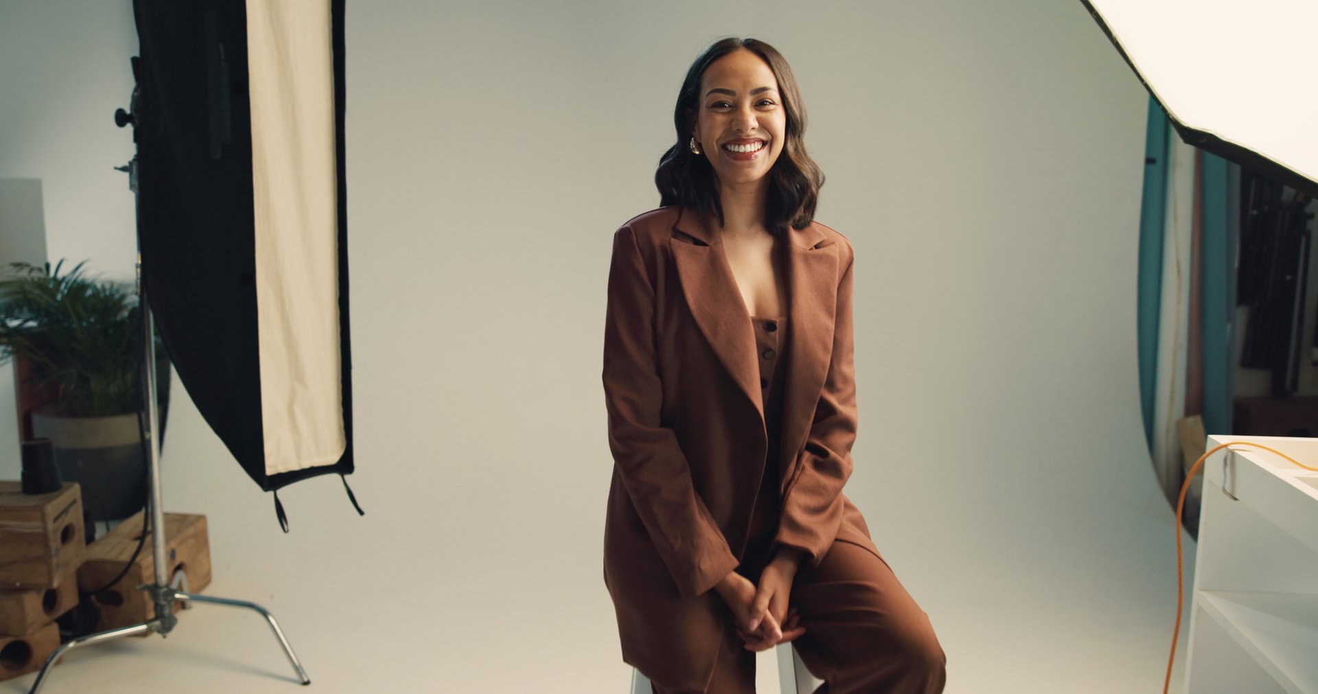 Photography, studio and model with portrait backstage for fashion photoshoot, magazine catalog and creative career. Behind the scenes, woman and happy on set for campaign project and article cover