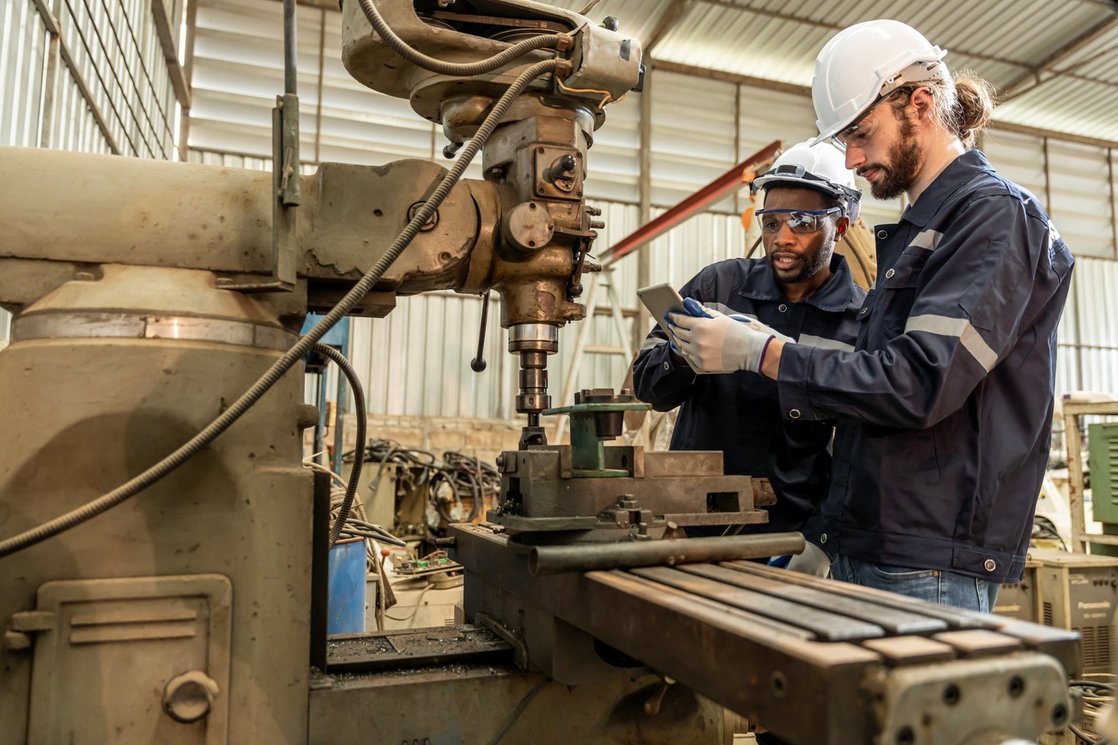 Team of engineers practicing maintenance Taking care and practicing maintenance of old machines in the factory so that they can be used continuously.