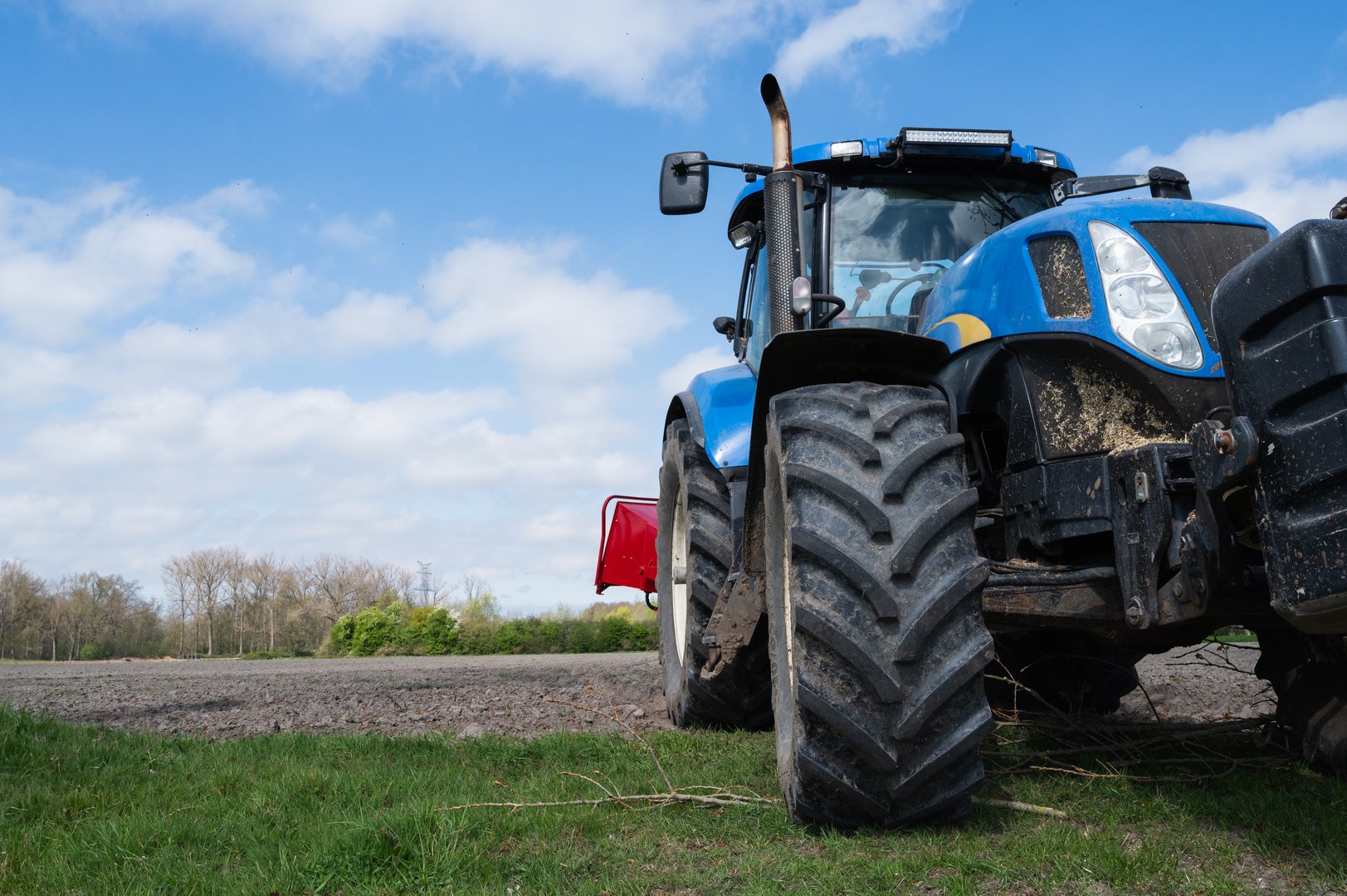 Powerful blue tractor on green grass field
