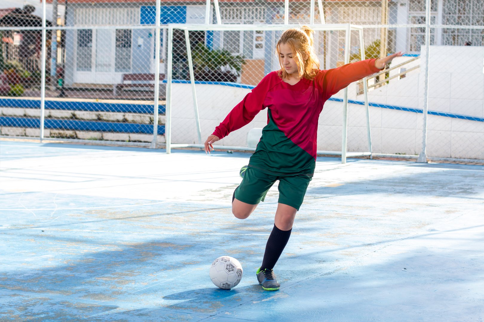 Concepts: women's sports and outdoor recreation. beautiful woman playing soccer kicking the ball. exercise and active lifestyle