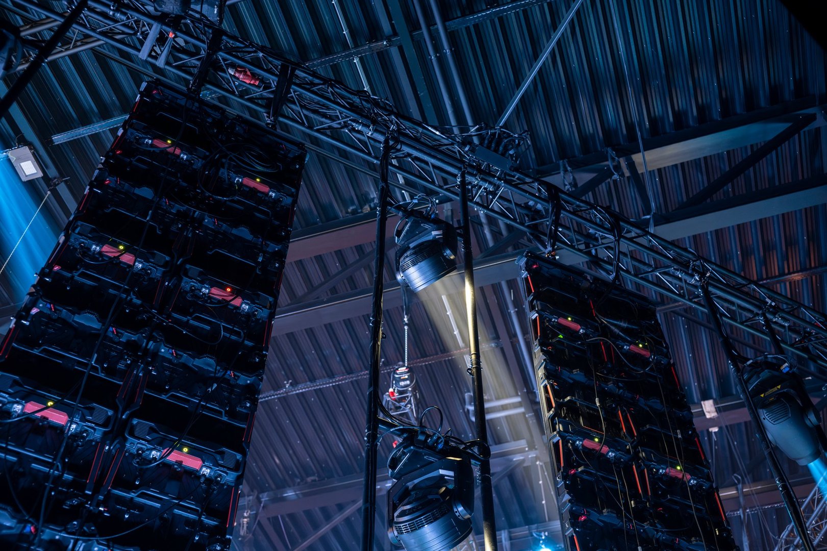 A close-up view of stage lighting and LED panels during a concert setup, highlighting the technical infrastructure required for a live performance.