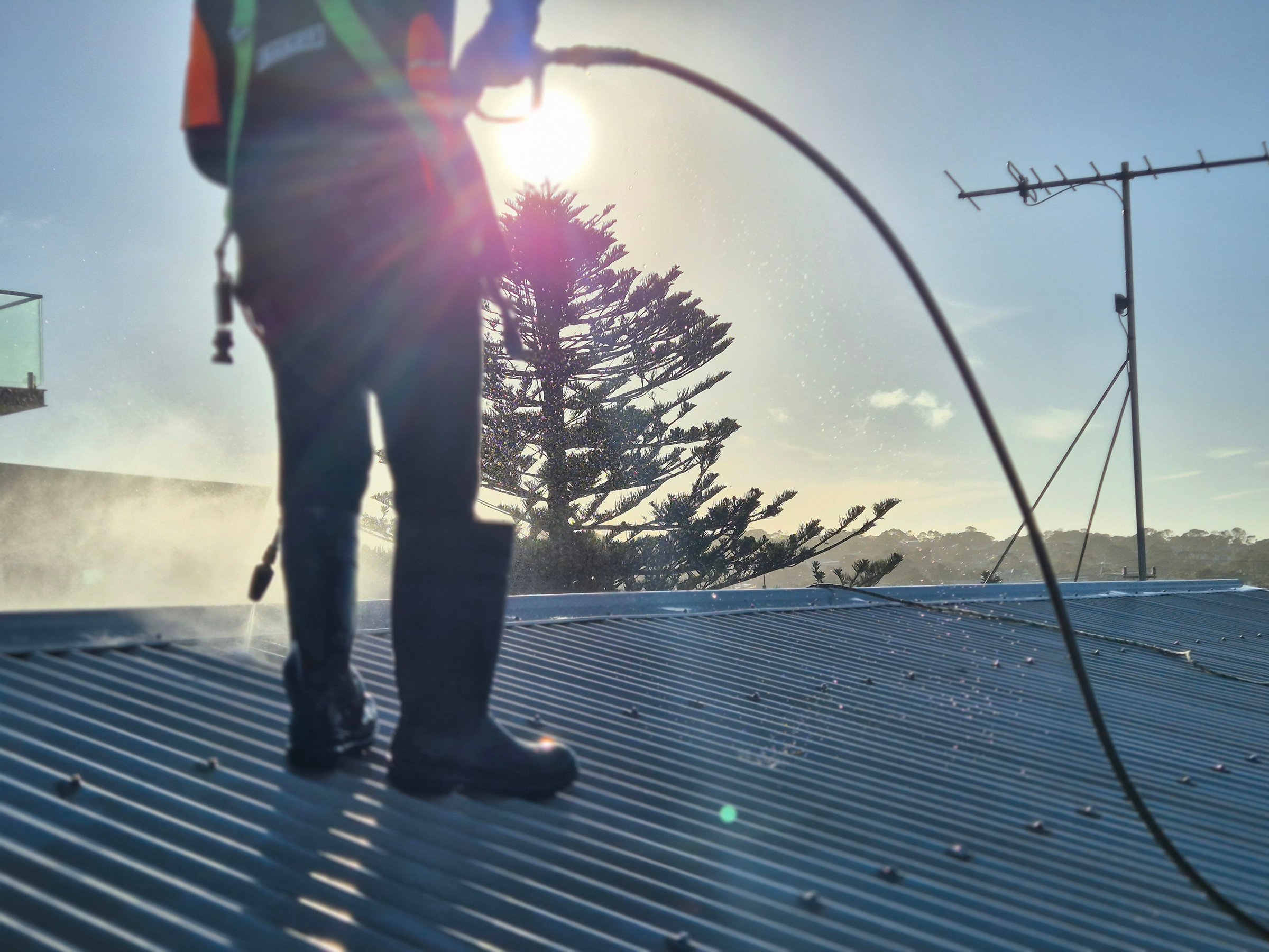 Pressure washing metal roof before painting - Quality Painting Group process