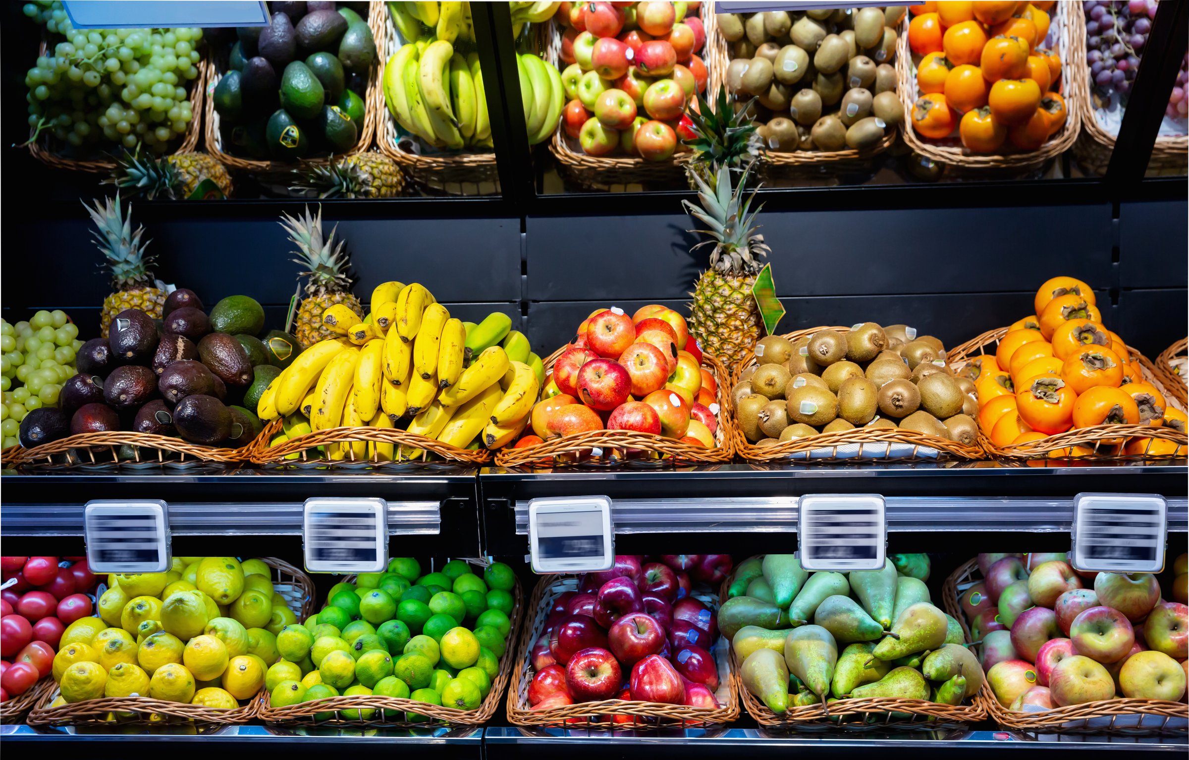 Fresh fruits in wicker baskets on shelf of supermarket