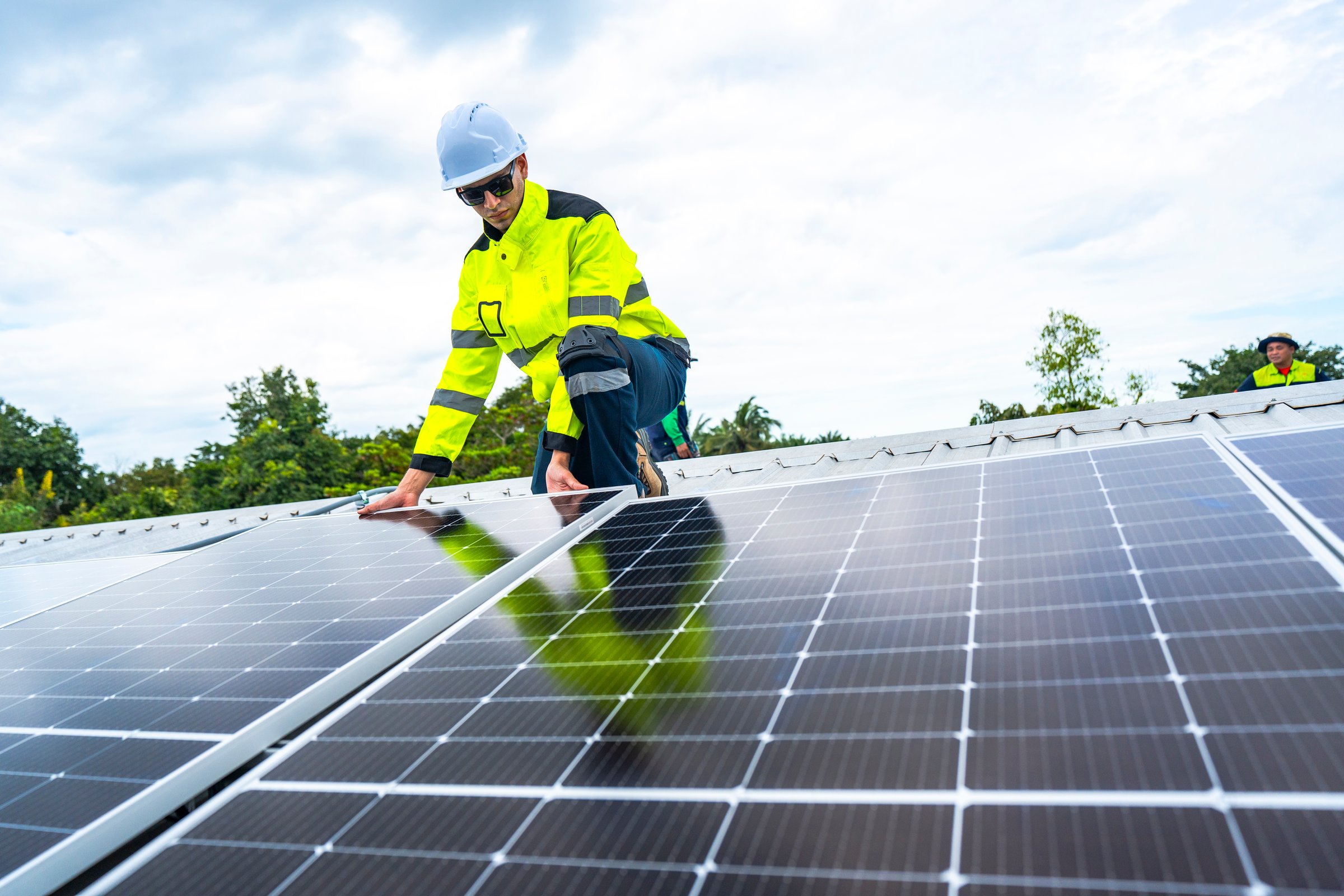 A skilled technician adjusts a solar panel on rooftop, emphasizing the transition to sustainable energy. Equipped with safety gear, the worker demonstrates precision in renewable energy installations.