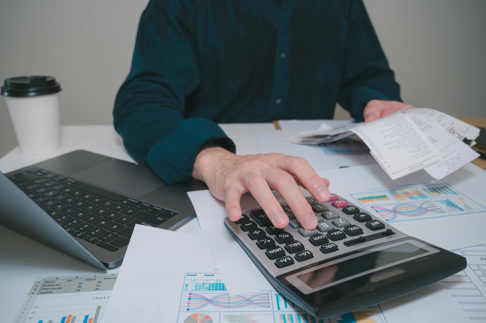 Close up of businessman hand calculating budget checking bills, using calculator to calculate home finance budget management. Doing finance, budgeting and tax calculation, monthly expenses