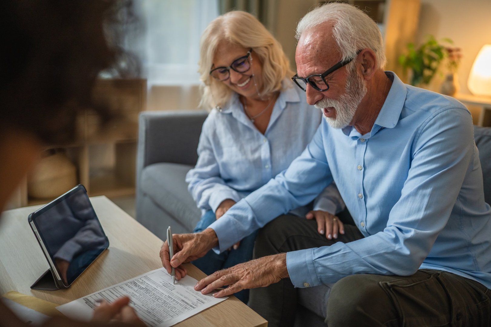 Senior couple sign insurance policy, contract to woman financial adviser at home