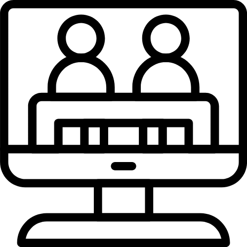Silhouette of a person sitting in front of a computer, working at a desk with a lamp and papers.